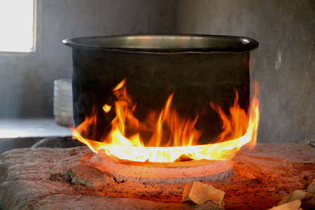 Traditional way of making food on open fire in old Indian kitchen in a village Chula.の写真素材
