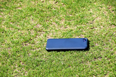 Mobile phone on fresh green grass texture as a backgroundの写真素材
