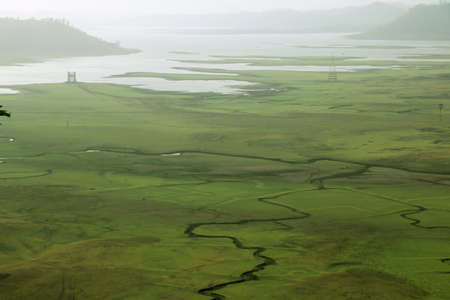 areal view of Green field water in river from top of the hillの写真素材