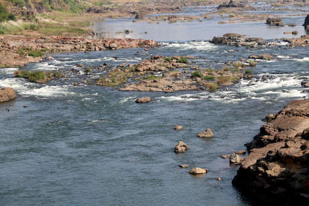 areal view of flowing water in river with big rock during summer in Indiaの写真素材