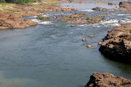 areal view of flowing water in river with big rock during summer in Indiaの写真素材