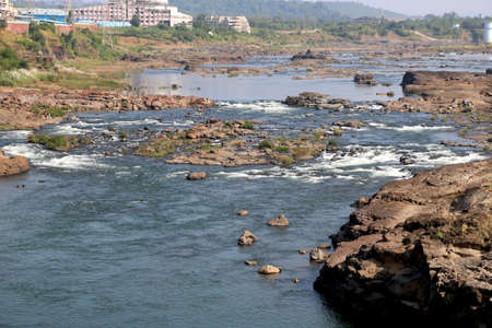 areal view of flowing water in river with big rock during summer in Indiaの写真素材