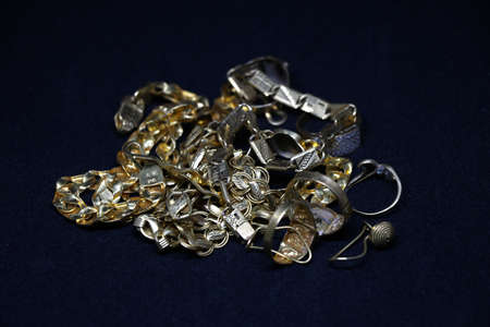 gold jewelry with gold chain ring earring with black backgroundの写真素材