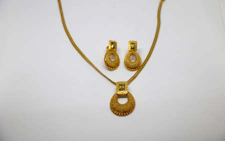 Gold necklaces and earrings on white backgroundの写真素材
