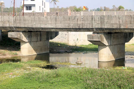 Landscape view of concrete bridge on river and algae on waterの写真素材