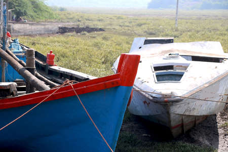 Wooden boats parked at dry land after fishing in Indiaの写真素材