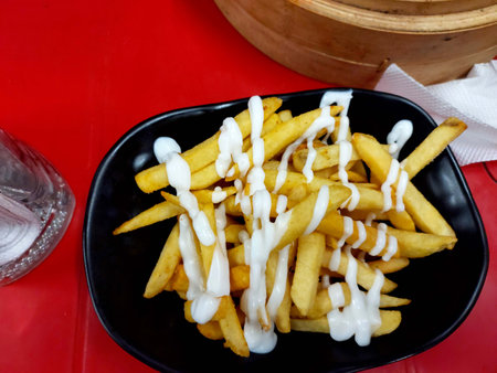 French fries in black bowl on serving tableの写真素材