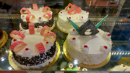 arious Cake with Icing in Refrigerated Bakery Case Cabinet.の写真素材