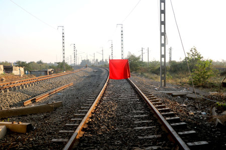 The longest railroad tracks with stop red flag close signalの写真素材