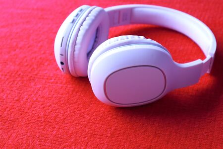 Wireless Pink Headphones, isolated in red fabric background, use for listening music and watch movie...