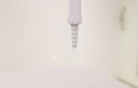 White Faucet with drop of water flowing into sink in laboratory, use for cleaning or washing hands prevent coronavirus (COVID-19) in medical room or clinic isolated in white background has copy space.の写真素材