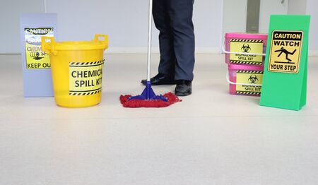 Janitor male cleaning floor in medical service room or laboratory with caution tag sign watch your step and Biohazard spill kit, chemical spill kit yellow bucket for response chemical spill out cases.の写真素材