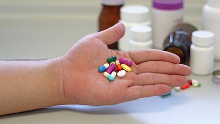 Obesity patient take medicine colorful tablets, pills and capsules in hand for treatment and cure disease or sickness. Drug prescription use for medication in medical clinic, pharmacy service concept.の写真素材