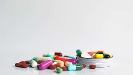 Close up of Medicines in bottle cover cap, colorful pills, tablets and capsules isolated in white background. Drug prescription use for medication in medical clinic, pharmacy pharmaceutical service.の写真素材
