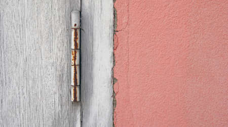 Old and dirty vintage wooden door with orange concrete wall, old construction with rust home and...