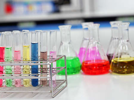 The Erlenmeyer conical Flasks and test tubes with rack on bench laboratory, with colorful solvent for testing indicator, titration experiment, acidity, alkalinity, and hardness in waste water sample.の写真素材