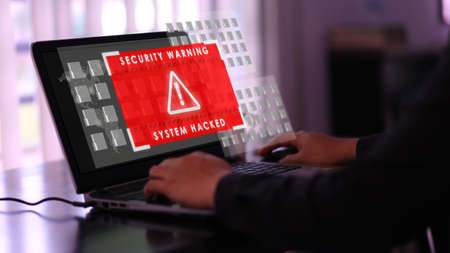 Virtual security warning system hacked alert on laptop screen. Cybersecurity vulnerability on internet, virus, data breach, malicious connection. Selective focus.の写真素材