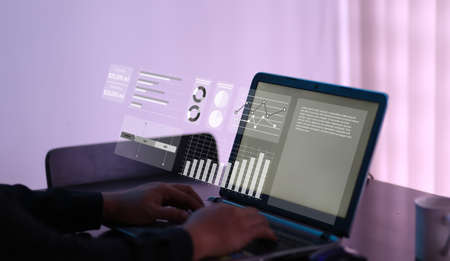 User typing on a laptop with virtual screen of performance graph dashboard. Concept for financial, business, progress performance and dashboard.の写真素材