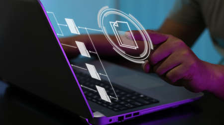 User working on laptop with virtual screen of Document Management System (DMS), a virtual online documentation database. Concept for business and office management. Selective focusの写真素材