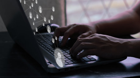 User typing on a laptop with virtual screen of networking and wold map. Concept for networking and...