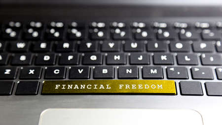 FINANCIAL FREEDOM word on laptop keyboard button. Concept business and financialの写真素材