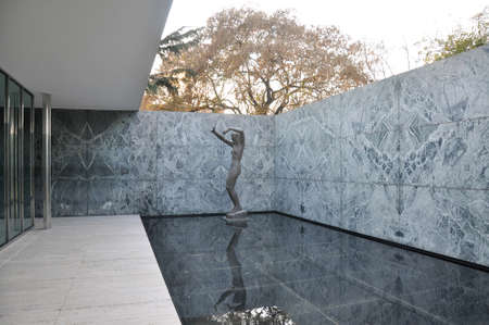 Attractive geometric patio with female statue at one corner and a shallow reflecting pool in Barcelona Pavilion by Ludwig Mies van der Roheのeditorial素材