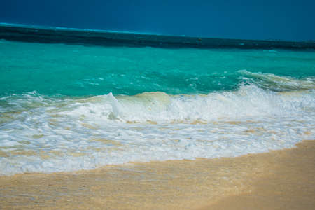 Gentle surf lapping at golden sand on an idyllic tropical beach in the Turks and Caicos Islands, Caribbean, North Americaの写真素材