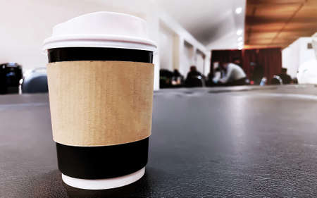 A take away coffee cup with blur background of modern loft coffee shopの写真素材