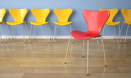 interior design row of yellow chairs against a blue wall with one red in frontの写真素材