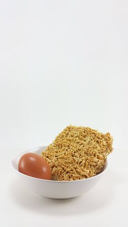 preparing for cooking instant noodle with egg in a bowlの写真素材