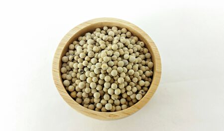 closed up white pepper in deep wooden bowl on white backgroundの写真素材