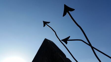 Silhouette arrow point up on the clear bright blue skyの写真素材