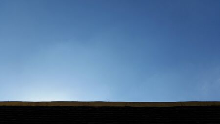 Clear blue sky over roof top - plain backgroundの写真素材