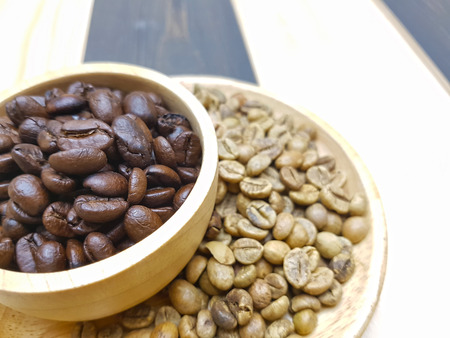 Roasted and raw coffee bean in multi-level wooden plateの写真素材