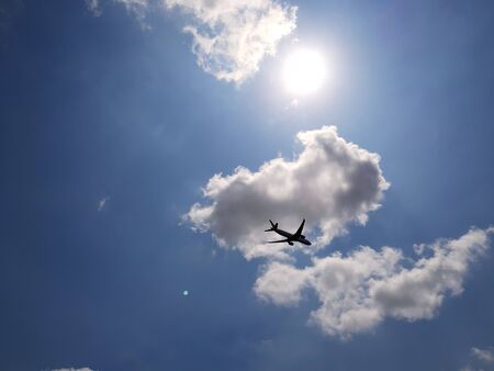 Cloud, Sun, Blue sky and flying airplaneの写真素材