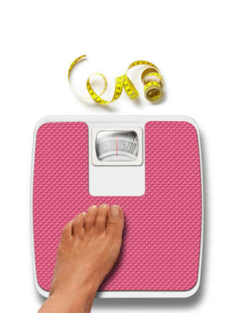 Woman feet and pink weight scale isolated on white backgroundの写真素材