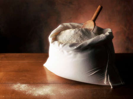 Flour in canvas bag on wooden table and brown backgroundの写真素材