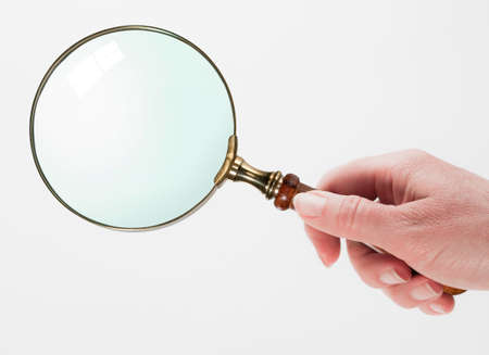 Woman hand holding magnifying glass isolated on white backgroundの写真素材