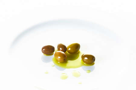 Olives in a white plate and white backgroundの写真素材