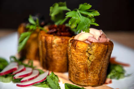 Bananas stuffed with ham meat and sauces with vegetables aroundの写真素材
