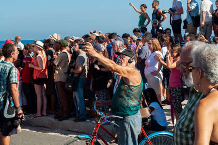 HAVANA, CUBA - 08/14/2019. Old man taking a selfie with a cell phone in a concentration of many...