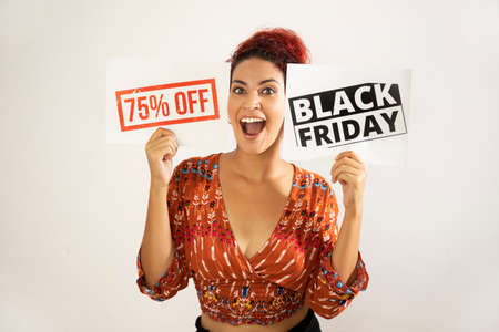 Very happy girl smiling showing two posters of Black Friday and 75% off. Young woman with white skin...