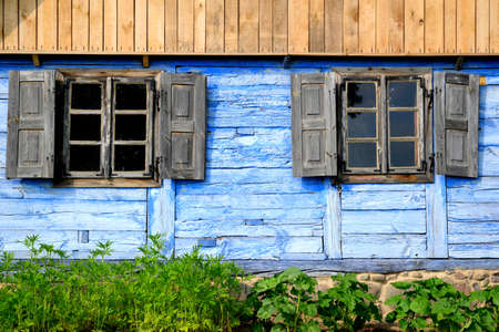 old windows with shutters on blue wall farmhouseの写真素材