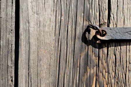 A fragment of an old wooden door closed on a steel skeletonの写真素材