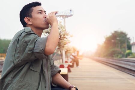 Man drink water while waiting for the trip.の写真素材