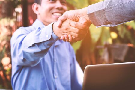 Friendly business man giving a handshake and smilingの写真素材