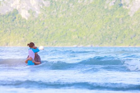 Grandmother embraces or hug granddaughter in the sea.