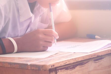 Close-up of writing hands and thinking of uniform students to test at school,の写真素材