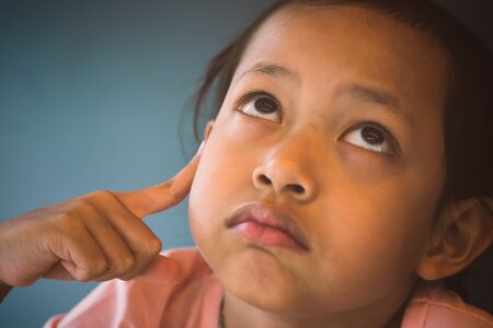 Sad asia child is thinking.の写真素材