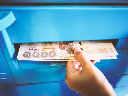 Hand of woman receiving money from the ATM.